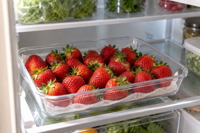 Strawberries in a shallow punnet in the fridge